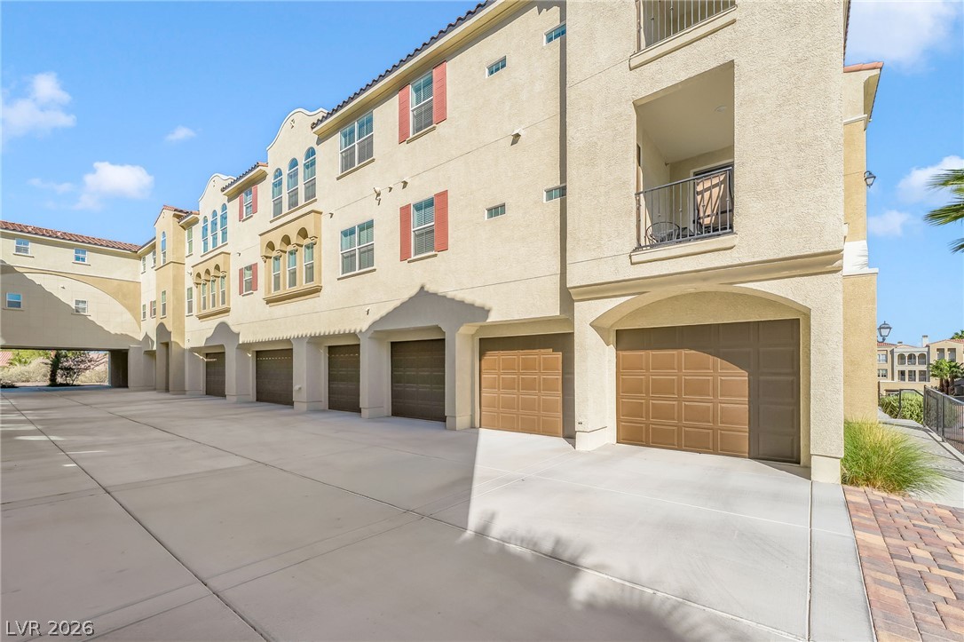 2555 Hampton Road, Unit 10108 Henderson, NV 89052 - Photo 3 of 23 Multi-car garages sit beneath multi-level units featuring private balconies and stucco exteriors.