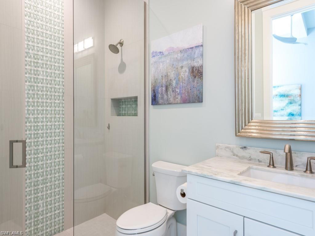 16892 Brightling Way Naples, FL 34110 - Photo 13 of 33 a bathroom with a granite countertop sink toilet and shower