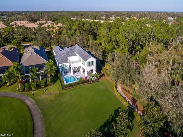 an aerial view of residential houses with outdoor space and trees