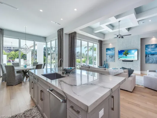 a kitchen with granite countertop a sink a counter top space and living room view
