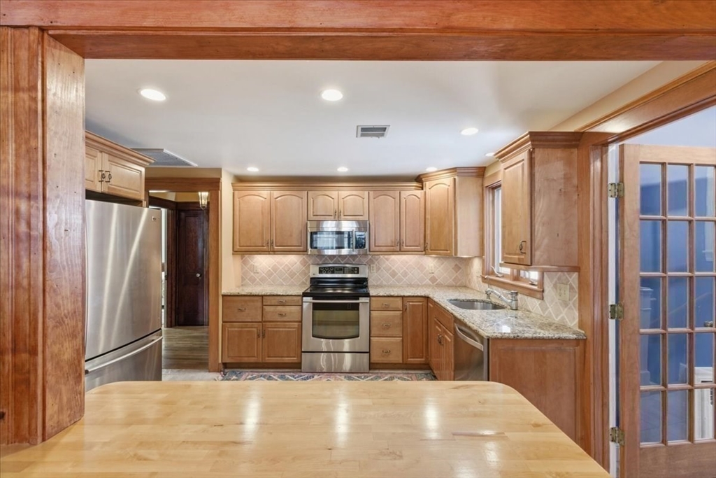 7 West Street Needham, MA 02494 - Photo 12 of 36 a kitchen with stainless steel appliances granite countertop a refrigerator a stove and a sink