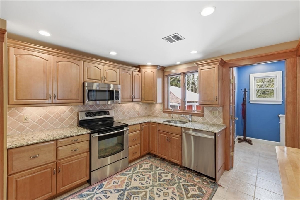 7 West Street Needham, MA 02494 - Photo 15 of 36 a kitchen with stainless steel appliances granite countertop a stove sink and cabinets