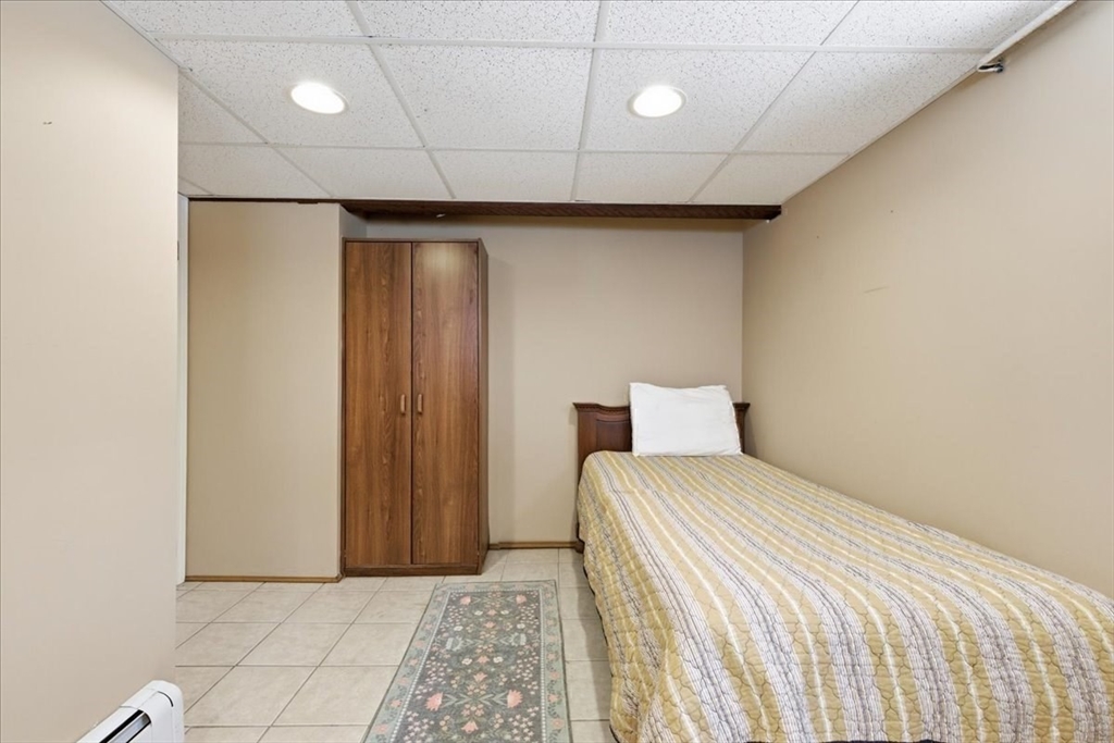 7 West Street Needham, MA 02494 - Photo 31 of 36 a bedroom with a bed and a painting on the wall