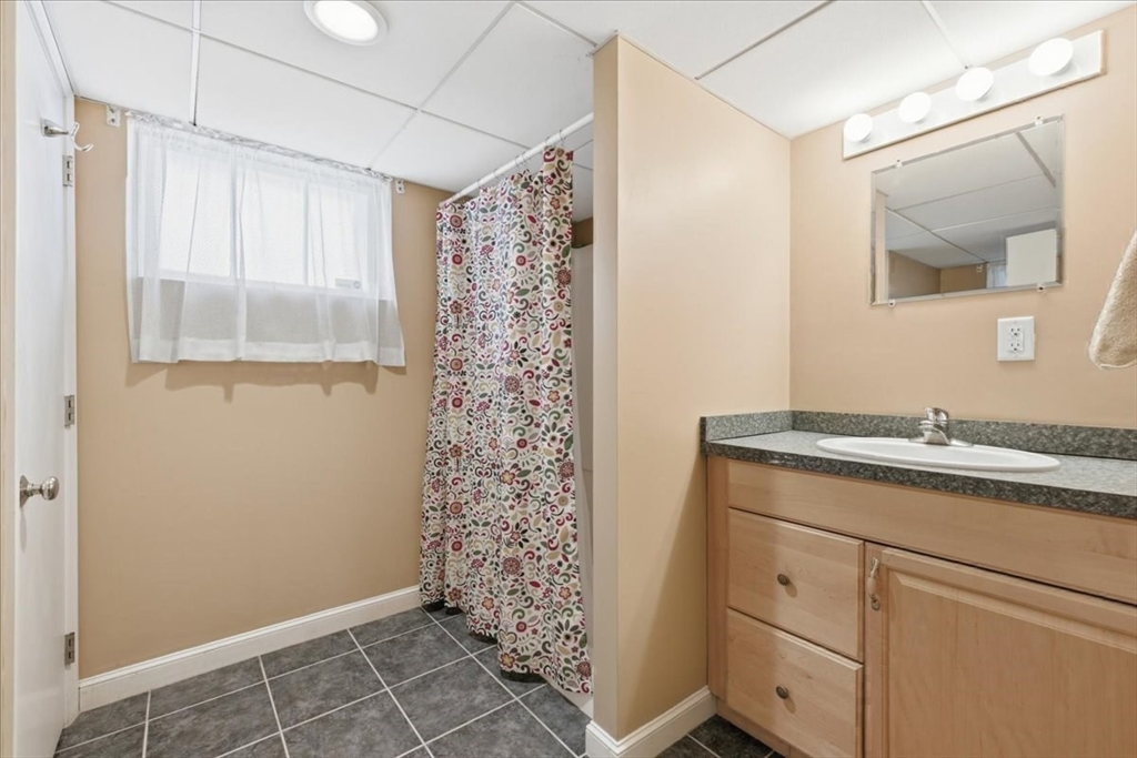 7 West Street Needham, MA 02494 - Photo 32 of 36 a bathroom with a granite countertop sink a mirror and shower