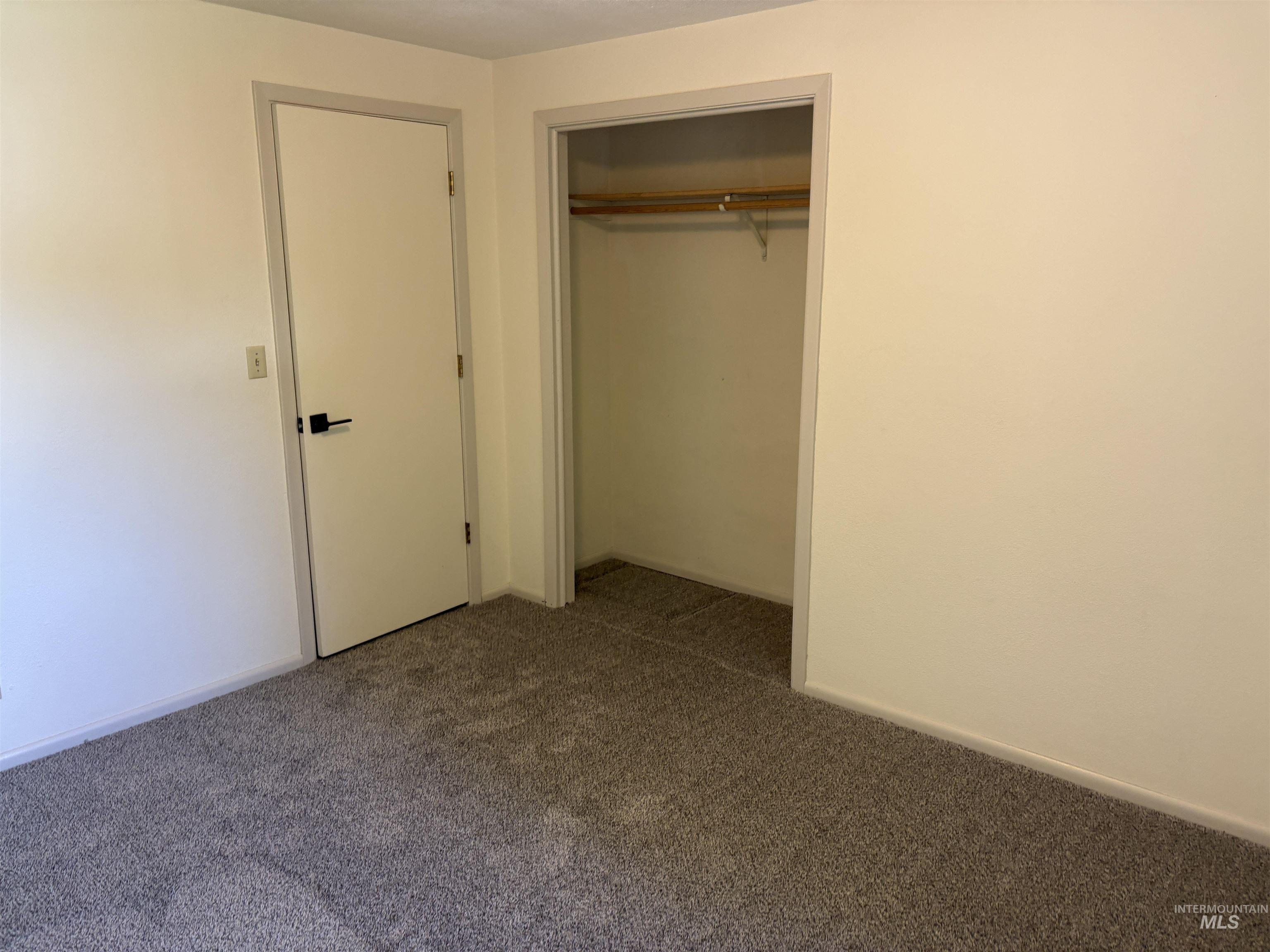 513 Ridge Way Ontario, OR 97914 - Photo 20 of 29 Neutral-toned room featuring a window with white trim, bi-fold closet doors, and grey carpet flooring