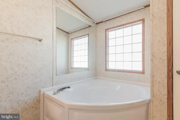 a bathroom with a granite countertop sink a mirror and a bathtub