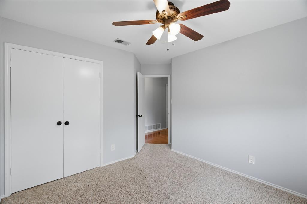 2074 Briarcliff Road Lewisville, TX 75067 - Photo 23 of 40 Carpeted room featuring a ceiling fan with integrated lighting, bi-fold closet doors, and light gray wall paint