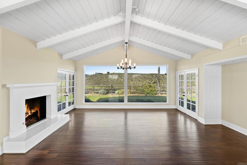16551 Zumaque Street Rancho Santa Fe, CA 92067 - Photo 4 of 11 a view of a room with wooden floor fireplace and windows