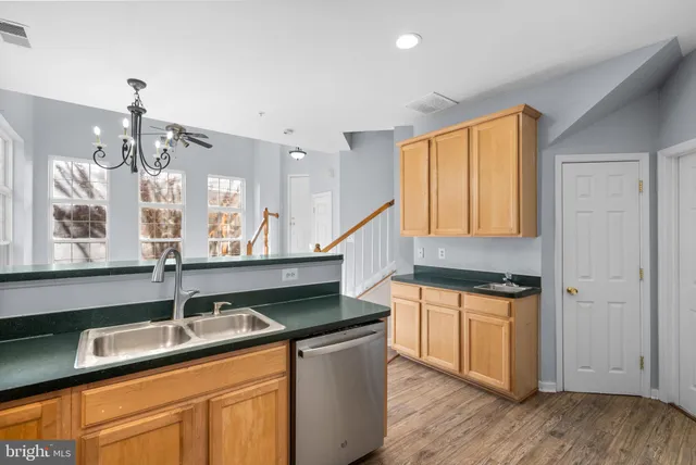 a kitchen with stainless steel appliances granite countertop a sink a stove and cabinets