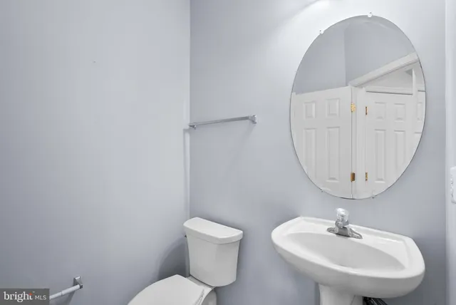 a bathroom with a toilet a sink and mirror