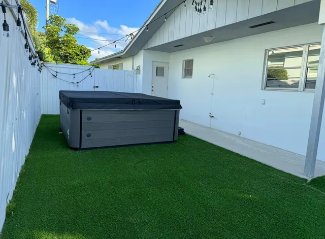 a backyard of a house with wooden fence and large trees