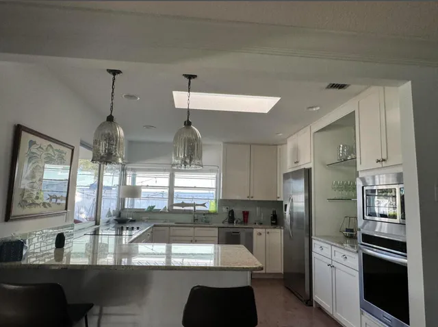 a kitchen with stainless steel appliances granite countertop a refrigerator and a sink
