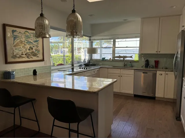 a kitchen with stainless steel appliances granite countertop a sink a stove and wooden floor