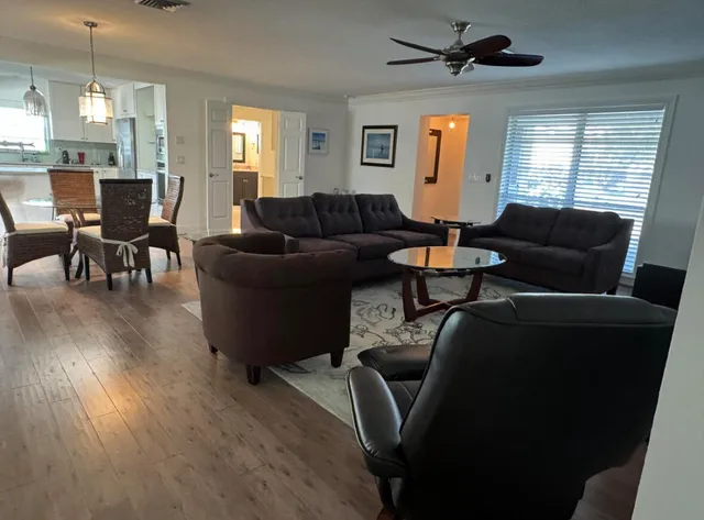 a living room with furniture a ceiling fan and a window