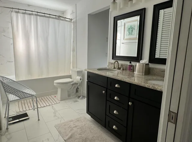 a bathroom with a double vanity sink toilet and a mirror
