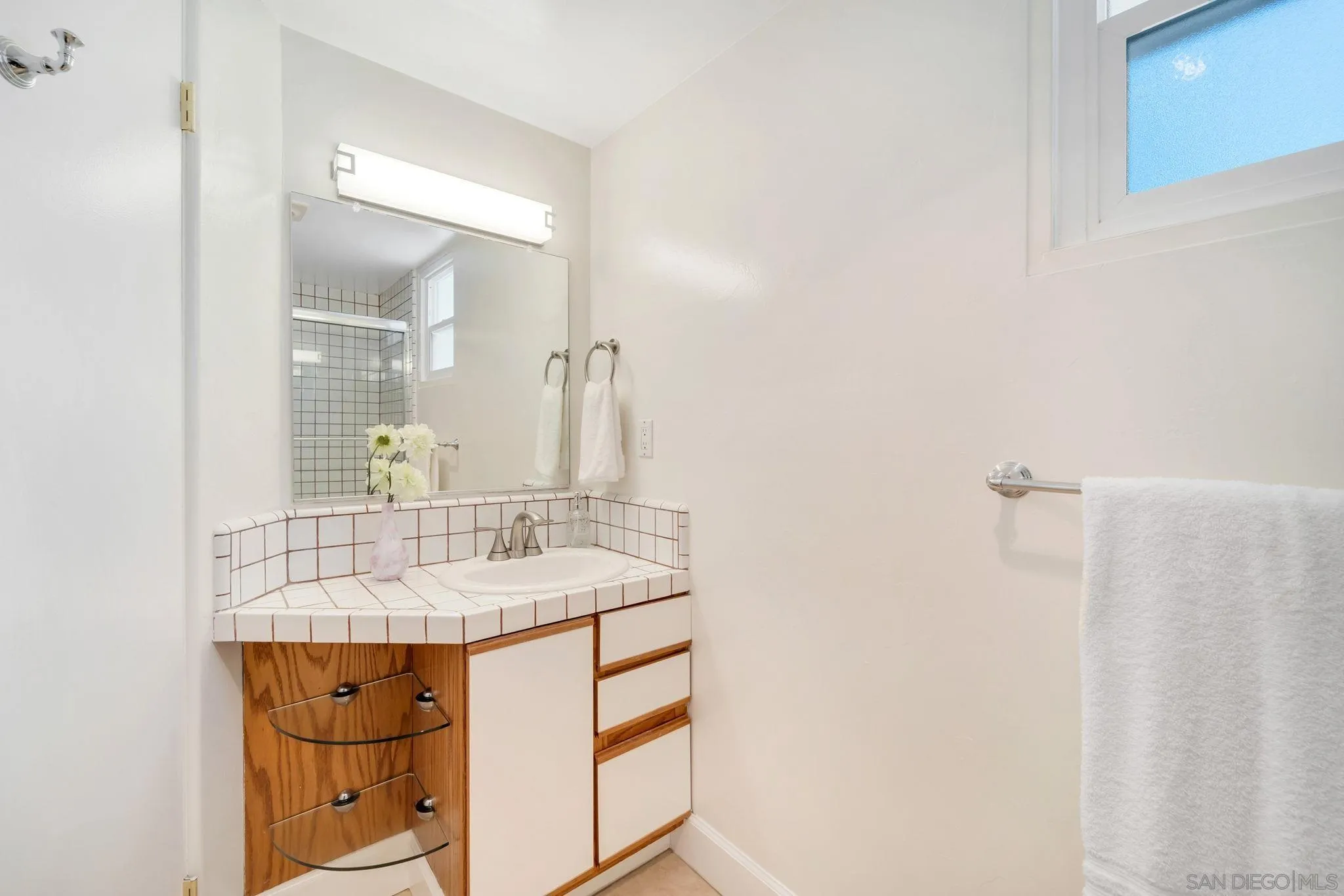 914 Agate Street, Unit E San Diego, CA 92109 - Photo 11 of 24 a bathroom with a sink and a mirror