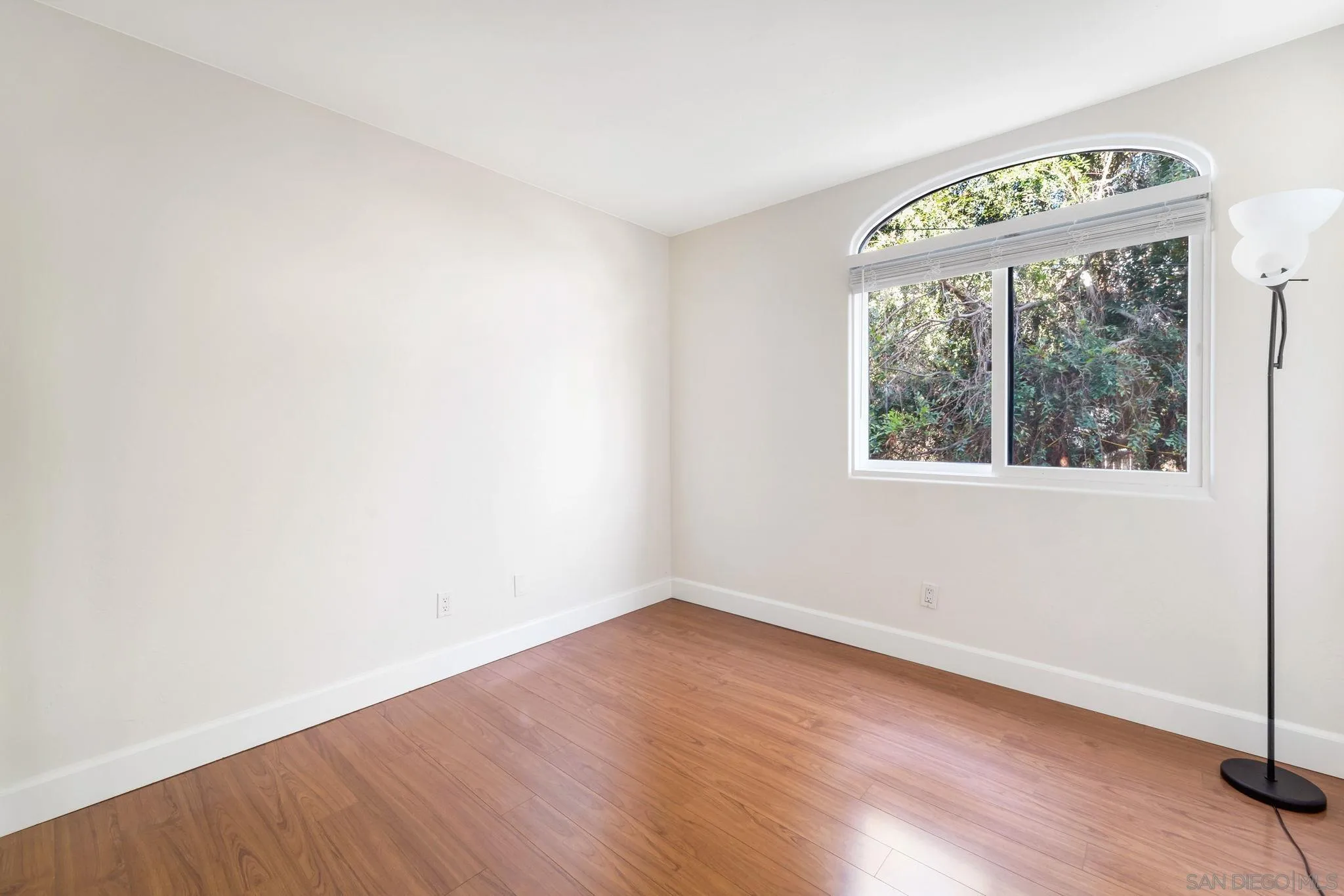 914 Agate Street, Unit E San Diego, CA 92109 - Photo 15 of 24 an empty room with wooden floor and windows