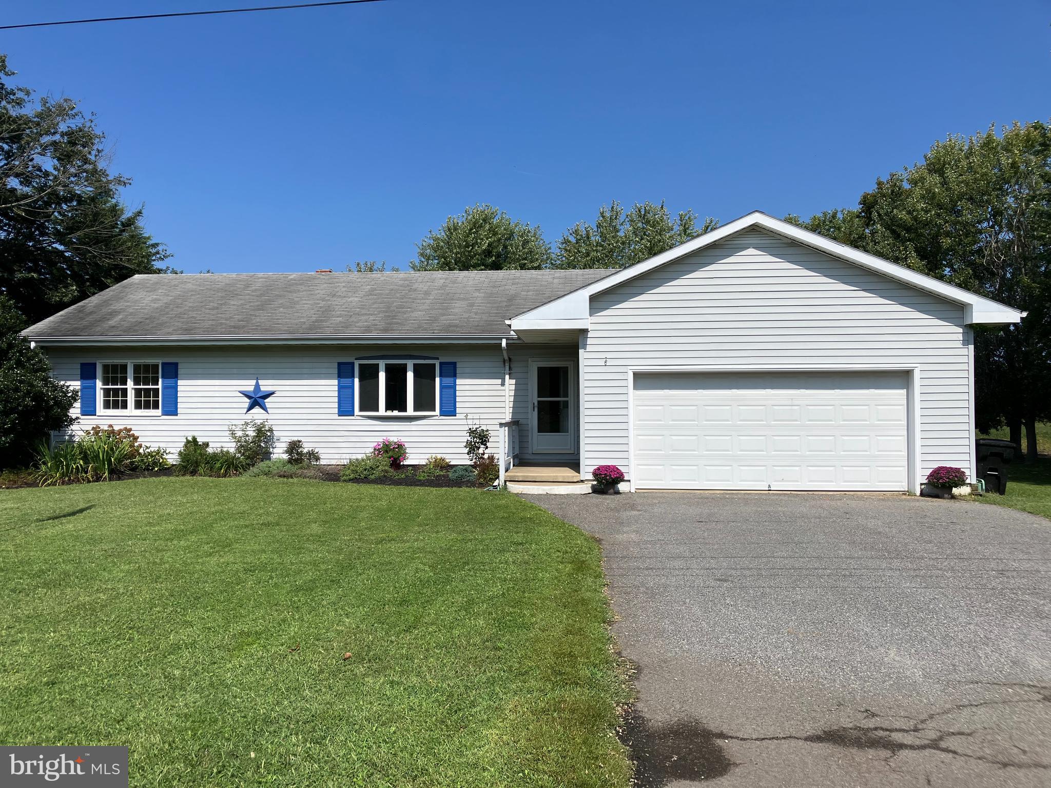 a front view of a house with a garden and yard