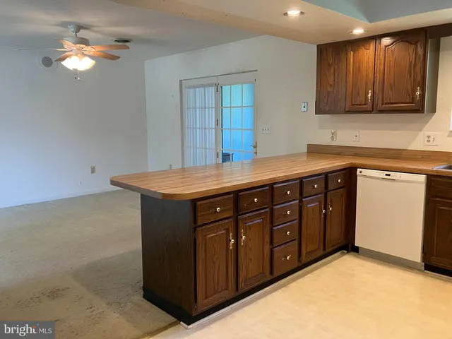a kitchen with stainless steel appliances granite countertop a sink dishwasher and a stove with wooden cabinets