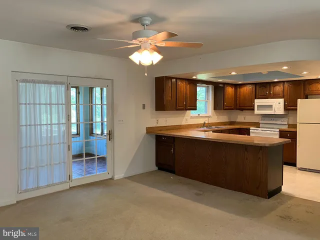 a large kitchen with stainless steel appliances granite countertop a stove and a refrigerator