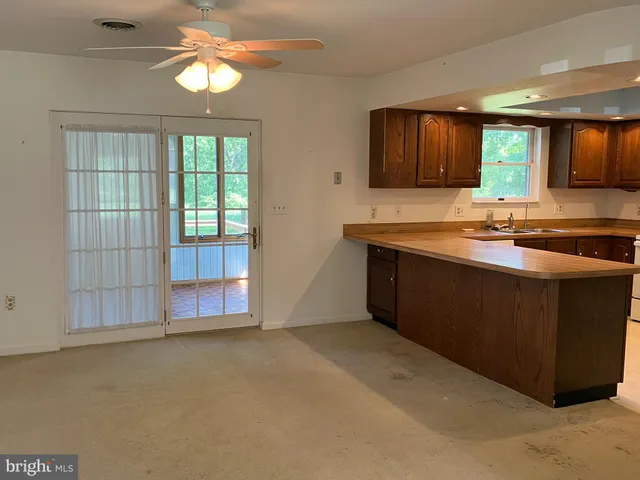 a kitchen with kitchen island granite countertop a sink and a stove top oven