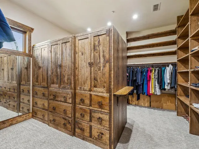 a view of walk in closet with clothes and shoes
