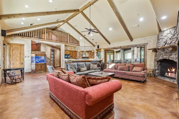 a living room with furniture a fireplace and a large window