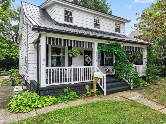 a view of a house with a small yard and flower plants