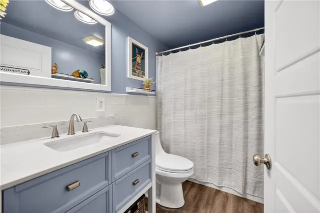 a bathroom with a granite countertop sink toilet and shower