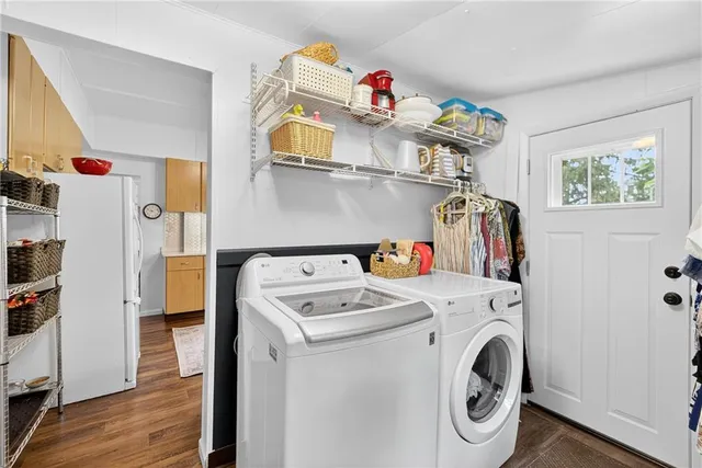 a utility room with dryer washer and a wooden floor