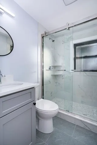 a bathroom with a granite countertop toilet sink and shower