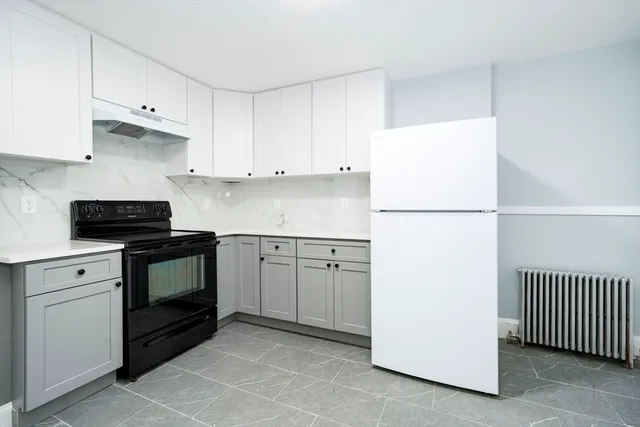 a kitchen with a refrigerator stove and white cabinets