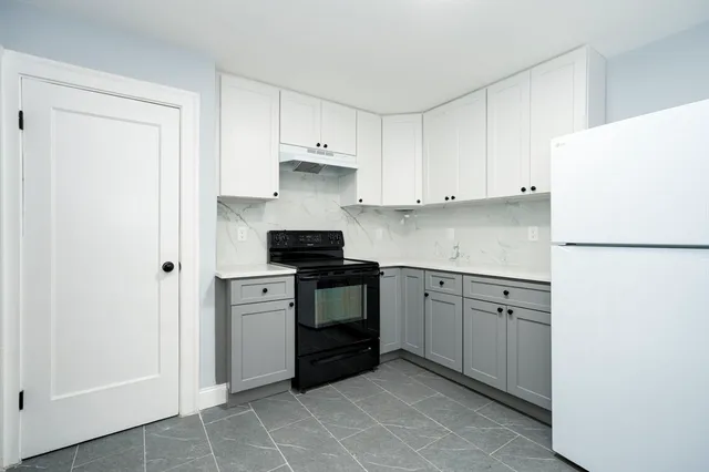 a kitchen with stainless steel appliances granite countertop a refrigerator sink and white cabinets