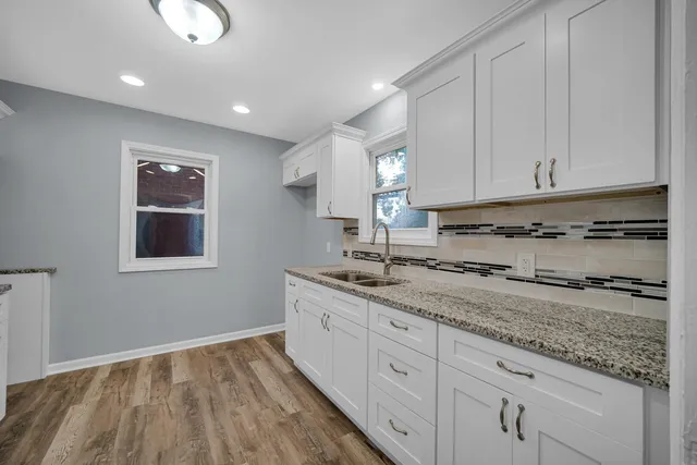 a kitchen with a sink window and cabinets