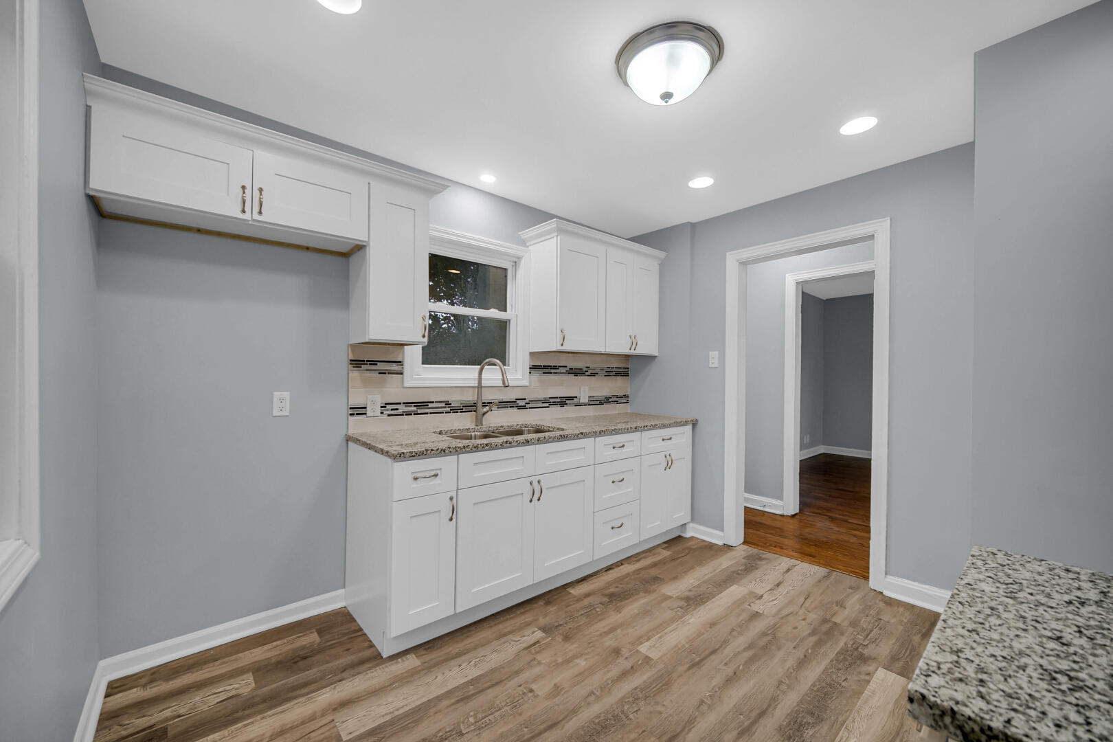 4810 Monroe Street Gary, IN 46408 - Photo 6 of 19 a kitchen with granite countertop a sink cabinets and wooden floor