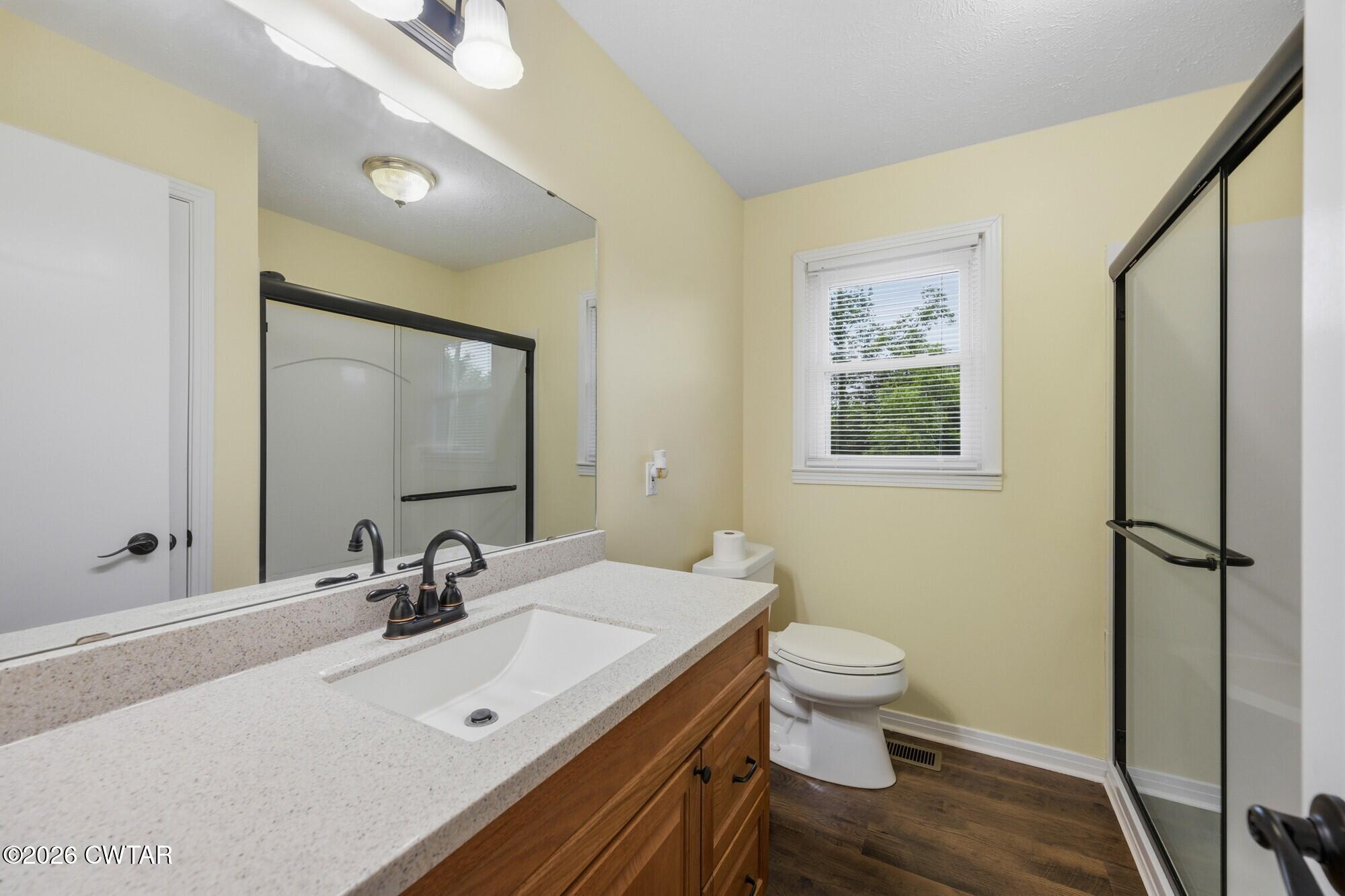 944 Brooksie Thompson Road Decaturville, TN 38329 - Photo 26 of 47 a bathroom with a sink a toilet and mirror
