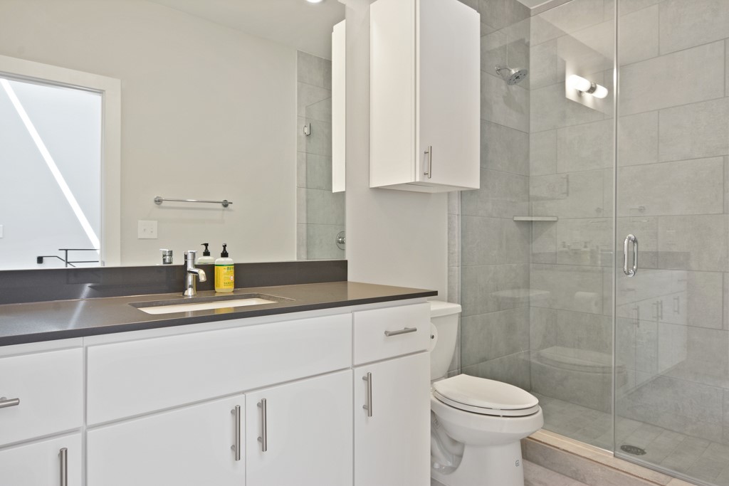 2002 East 7th Street, Unit 246 Austin, TX 78702 - Photo 20 of 25 a bathroom with a sink a toilet and a mirror