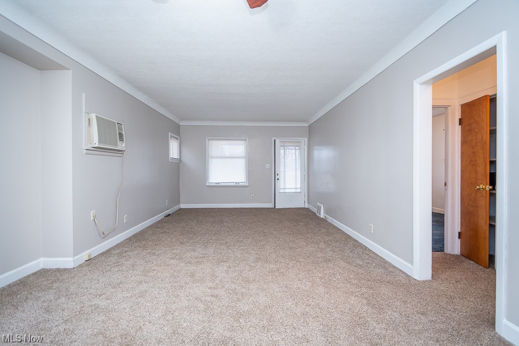 5220 Roseside Avenue Parma, OH 44134 - Photo 6 of 30 Carpeted spare room featuring a wall unit AC and crown molding