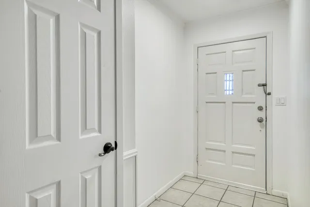 a view of an empty room with a ceiling fan and wooden floor