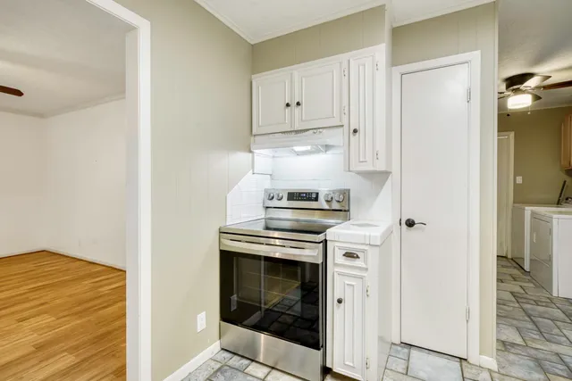 a kitchen with a sink a stove a refrigerator and cabinets
