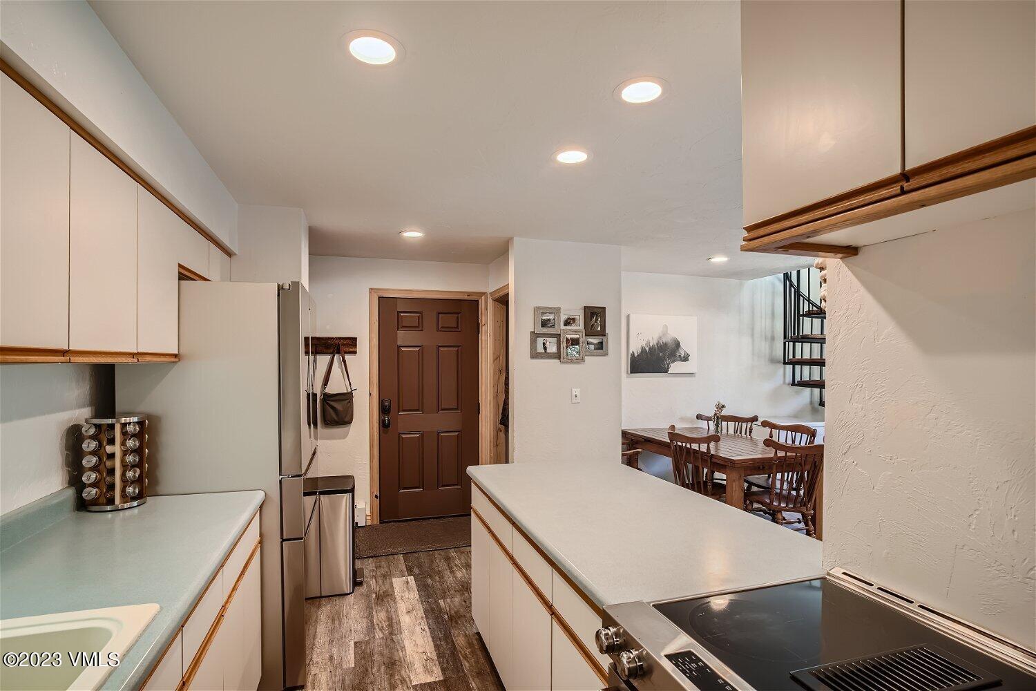 963 Lions Ridge Loop, Unit 503 Vail, CO 81657 - Photo 11 of 28 a kitchen with stainless steel appliances a stove a refrigerator a sink a refrigerator white cabinets and wooden floor