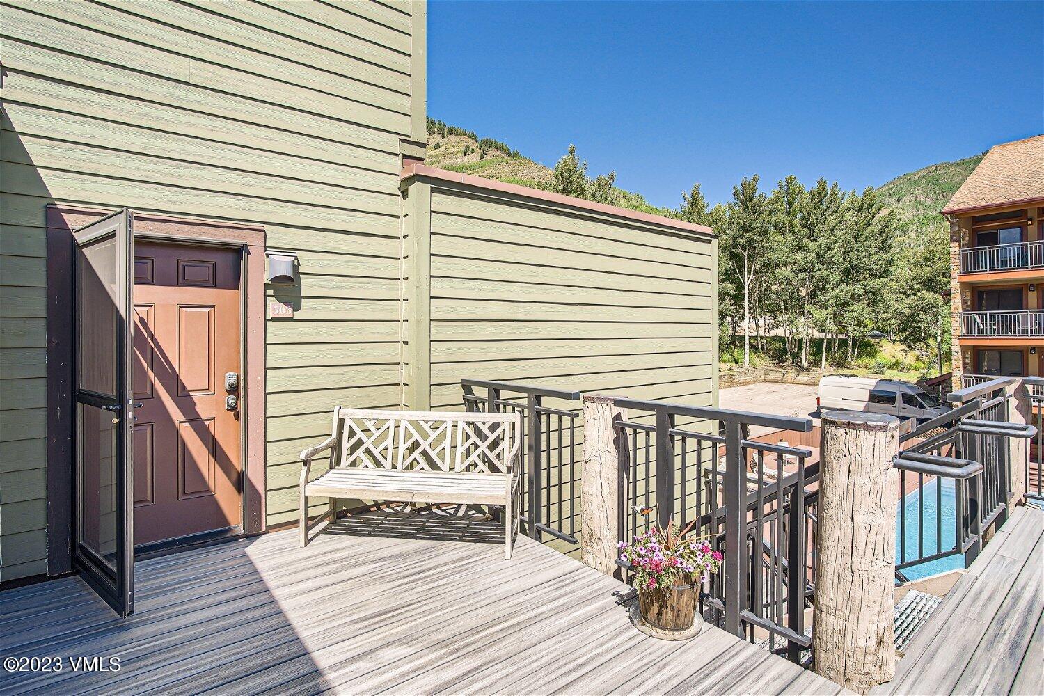 963 Lions Ridge Loop, Unit 503 Vail, CO 81657 - Photo 4 of 28 a view of a deck with wooden floor and fence next to a yard