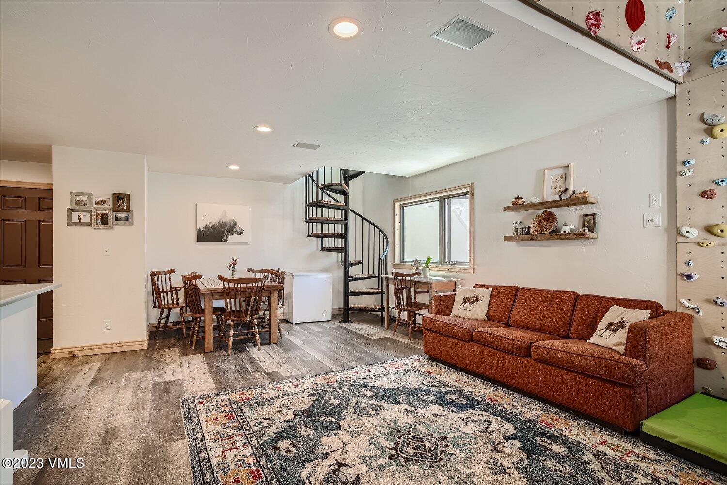 963 Lions Ridge Loop, Unit 503 Vail, CO 81657 - Photo 5 of 28 a living room with furniture and a dining table with wooden floor