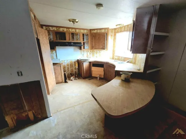 a kitchen with a sink a window and chairs