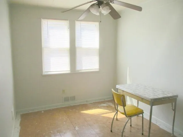 a view of a room that has a window and furniture