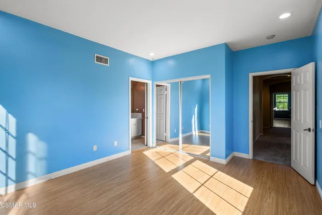 a view of a bedroom with wooden floor and bathroom