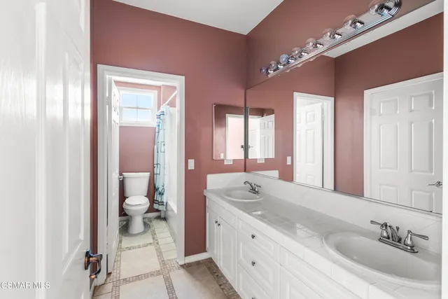 a spacious bathroom with double vanity sinks a mirror and a shower