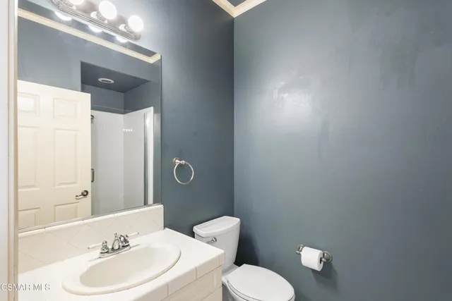 a bathroom with a sink vanity mirror and toilet