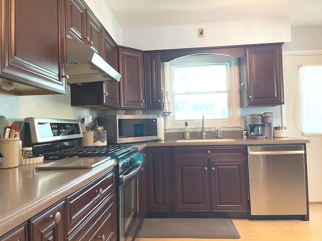 6118 Meyer Road Marengo, IL 60152 - Photo 12 of 42 a kitchen with stainless steel appliances granite countertop a sink a stove a microwave cabinets and a window