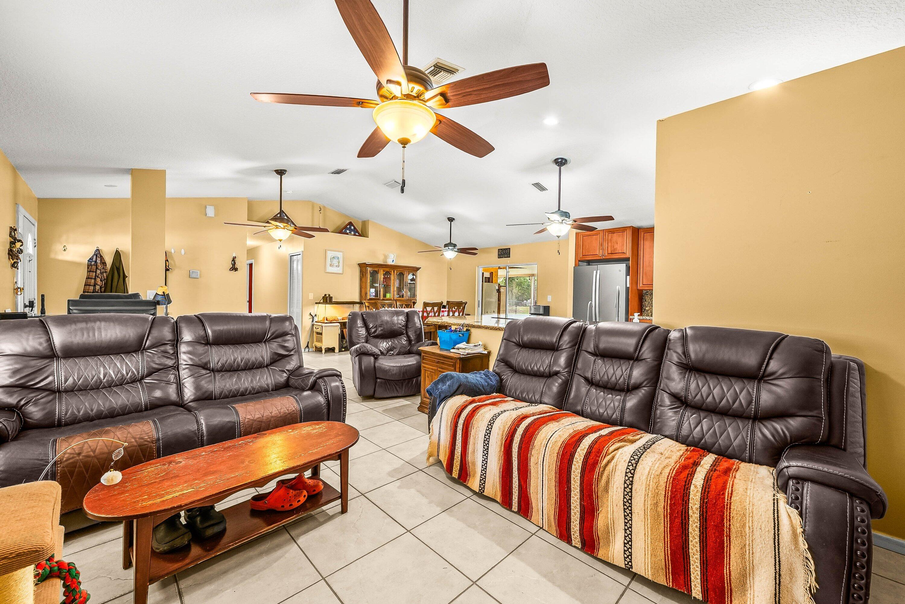 2195 F Road Loxahatchee Groves, FL 33470 - Photo 13 of 54 a living room with furniture a ceiling fan and a rug
